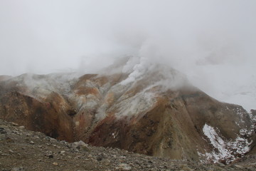 The top of the volcano in Kamchatka is shrouded in vapors, a beautiful mountain landscape.