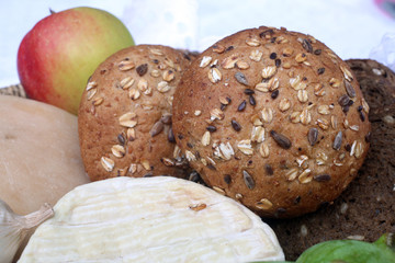 Rustic still life of bread, cheese and apple in a wicker basket