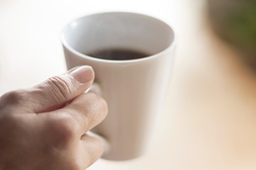 Female hand hold cup of coffee, selective focus