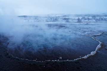Geothermal lake (hot spring pool) with smoke in Iceland at geysir Strokkur, golden circle