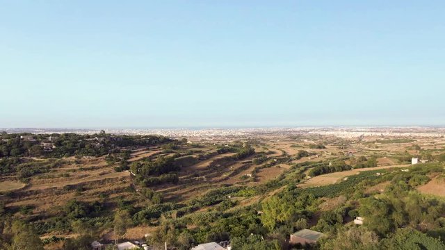 Aerial video moving forwards of the terraced fields of Buskette near the Palace of Vererdala Malta,