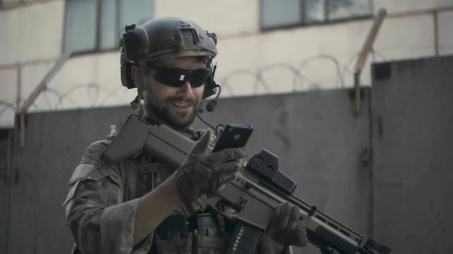 Soldier uses the phone in the city during the war