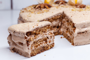  homemade, brown creamy cake with nuts and cream, on a light table