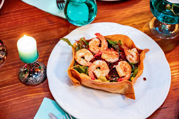Shrimps salad on green salad leaves bed, brunch buffet specialty dish. Food display during catering or private business event. Fresh seafood served