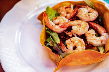 Shrimps salad on green salad leaves bed, brunch buffet specialty dish. Food display during catering or private business event. Fresh seafood served