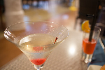 Cocktail martini with red cherry in the glass, close up shot