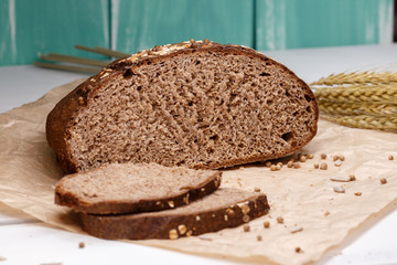 Homemade Black bread. Bread of rye dough on a craft paper. Rye bread for dinner. Fresh fragrant delicious homemade pastries.