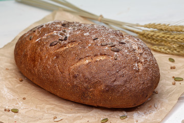 Homemade Black bread. Bread of rye dough on a craft paper. Rye bread for dinner. Fresh fragrant delicious homemade pastries.