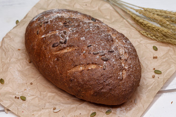 Homemade Black bread. Bread of rye dough on a craft paper. Rye bread for dinner. Fresh fragrant delicious homemade pastries.