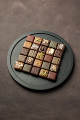 chocolates variety in black tray on brown background