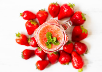 Strawberry smoothies or strawberries with ice in a jar. A refreshing summer drink. White background. Top view. Copy space