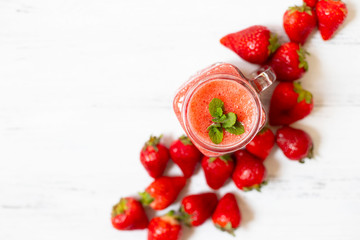Strawberry smoothies or strawberries with ice in a jar. A refreshing summer drink. White background. Top view. Copy space