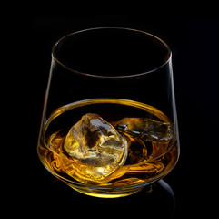 glass of whiskey with ice on a black background