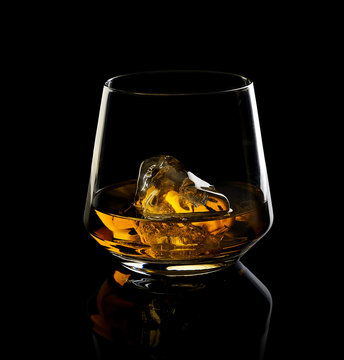 Glass Of Whiskey With Ice On A Black Background