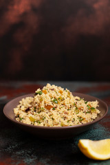 Traditional couscous with vegetables and herbs in a bowl. Levantine vegetarian salad. Lebanese, arabic cuisine. Close-up. Copy space