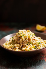 Traditional couscous with vegetables and herbs in a bowl. Levantine vegetarian salad. Lebanese, arabic cuisine. Close-up. Copy space