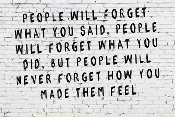 White brick wall with painted black motivational quote inscription
