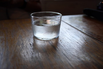 木製テーブルの上の結露した水のグラス