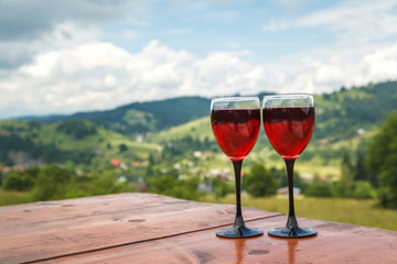 Two glasses of red wine on the background of the mountains, Ukraine, the Carpathian mountains.
