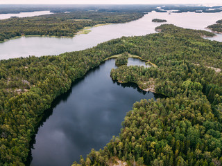 Fototapeta na wymiar Aerial view of blue lakes and green forests on a sunny summer day in Pentala island museum, Finland