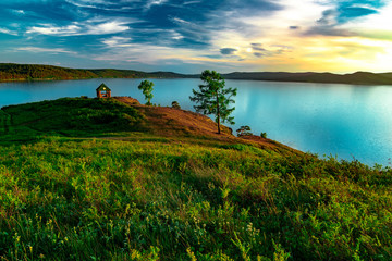 Beautiful landscape view of the mountain lake Turgoyak, Russia with cloudy sky and summer house on the hill in summer