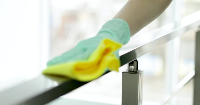 Professional janitor cleaning handrail with rag indoors, closeup