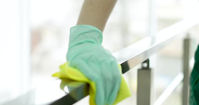 Professional janitor cleaning handrail with rag indoors, closeup