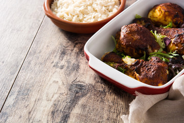 Roasted tandoori chicken with basmati rice on wooden table. Copyspace