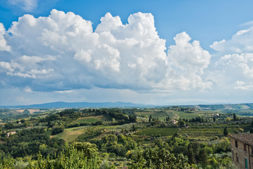Fototapeta na wymiar Panoramic view on a hills, vineyards, olive and cypress trees, Tuscany landscape around San Gimignano, Italy