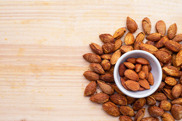 Almonds on wood background texture and copy space.