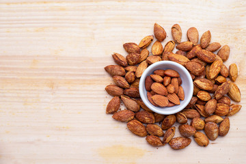 Almonds on wood background texture and copy space.