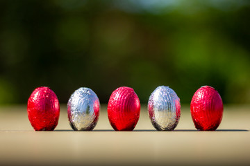 A row of easter eggs standing upright on a table.