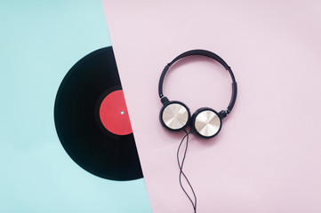 Retro style. Vinyl record, headphones on a pink-blue background. Top view. Minimalism. Music lover....