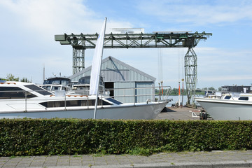 boats and crane on shipyard in small Dutch town
