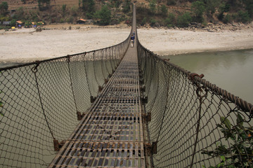 Panele Szklane  długi wiszący most linowy na rzece w nepalu i plaża w tle