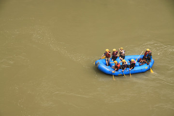 grupa ludzi  płynących pontonem rzeką