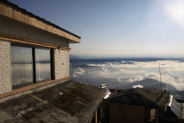 widok z wysoko położonego domu na górską okolicę w chmurach - obrazy, fototapety, plakaty