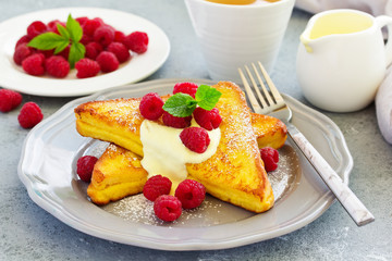 French toast with english sauce and raspberries.