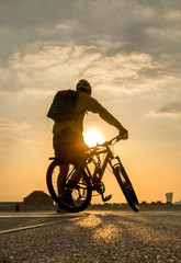 Fototapeta na wymiar silhouette of cyclist on bike at sunset