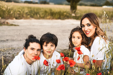 Portrait of a young family smiling and happy looking at the camera on the outside
