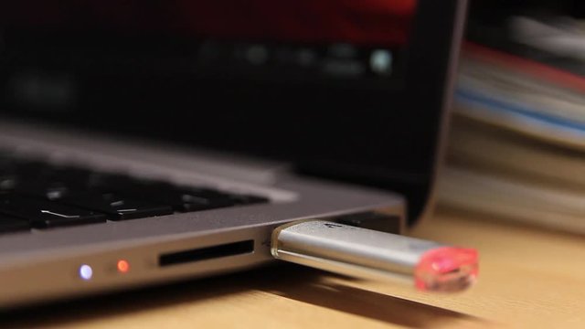 Insert a flash drive in a laptop. Close-up. A laptop. Technology.