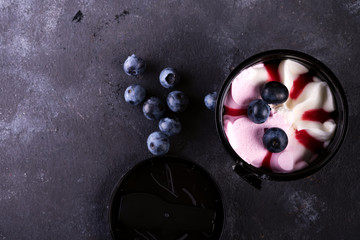 bucket of colorful ice cream with berries on a stone background, flat lay