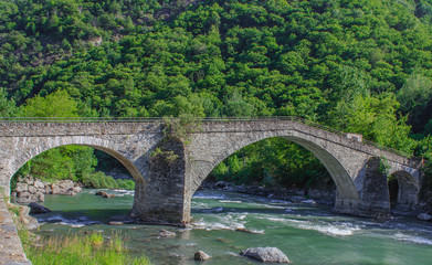 The medieval  bridge of Echallod in Arnad,  over the river  dora baltea in Aosta Valley//Italy.It is  a path of the famous way francigena, in the shape of a donkey's back,  formed by three  arches 