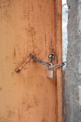 barricaded rusty door with door lock and chain