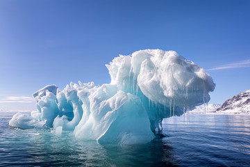 Blue ice iceberg floating in the arctic waters of Svalbard - obrazy, fototapety, plakaty
