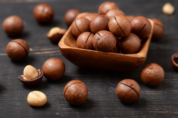 Group of macadamia nuts on  black wooden table