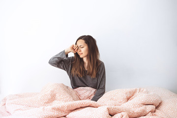 The girl is in bed. Early morning and she is sleepy. Early awakening