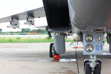 Arms under a plane wing of a military airplane.