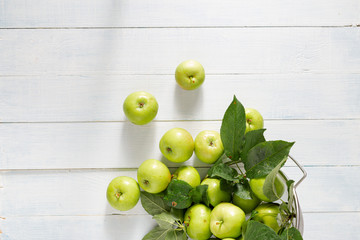 Pile of fresh green apple in colander on a wooden table top view
