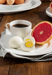 Boiled egg diet concept. Сooked eggs with grapefruit and a cup of black coffee